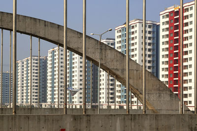 Low angle view of bridge against buildings in city