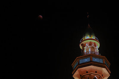 Low angle view of illuminated building against sky at night