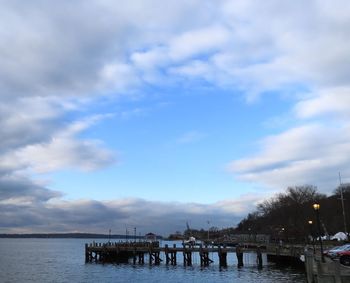 Wooden bridge over river against sky