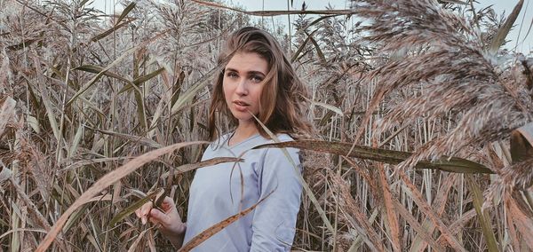 Portrait of woman standing by plants