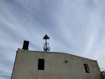 Low angle view of telephone pole against building