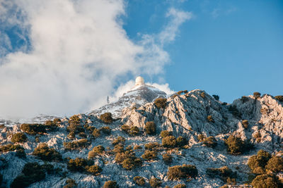 Low angle view of snowcapped mountains against sky