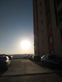 Cars parked on road against sky during sunset