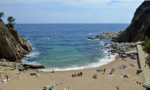 Group of people on beach by sea against sky