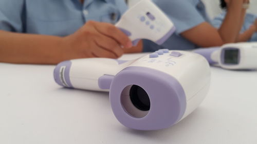 Close-up of man using smart phone on table