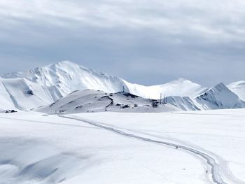 Scenic view of snow covered mountains against sky