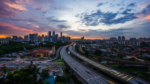 High angle view of street amidst buildings against sky during sunset