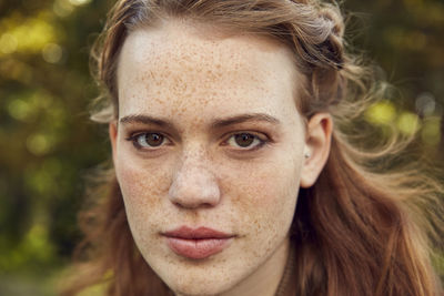 Portrait of redheaded young woman with freckles