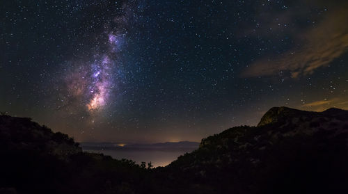 Scenic view of mountains against sky at night