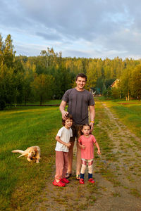 Father with kids and dog on countryside road