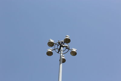 Low angle view of street lights against clear blue sky