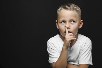 Portrait of boy against black background