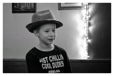 Boy wearing hat against wall at home