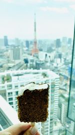 Close-up of hand holding ice cream in city