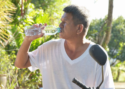 Senior asian people drinking purity water for quench thirst after finish work outdoor in hot day.