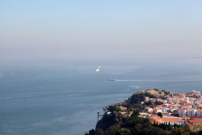 High angle view of townscape by sea against sky