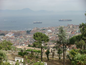 High angle view of town by sea against sky