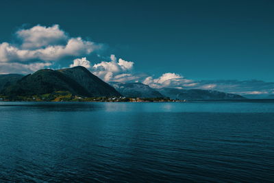 Scenic view of sea and mountains against sky