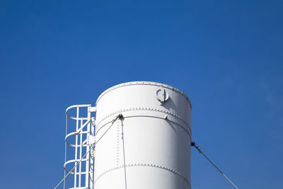 Low angle view of silo against clear blue sky