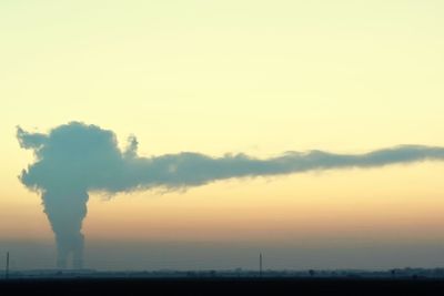 Smoke emitting from chimney against sky during sunset