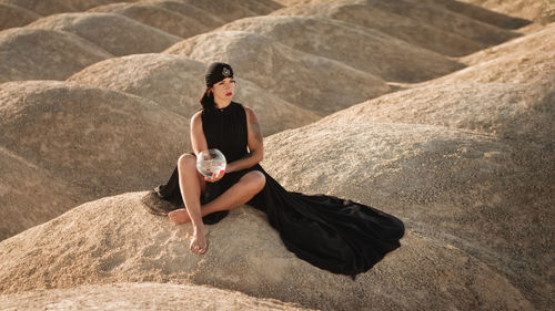 High angle view of woman sitting on rock