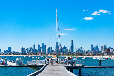 Sailboats in city against sky