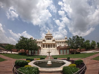 Fountain in garden against sky