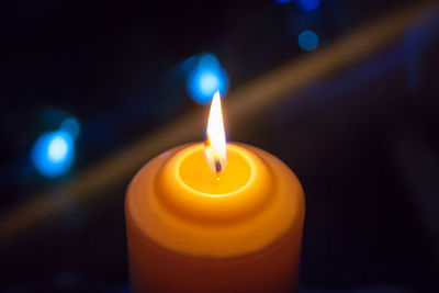 Close-up of lit candle in the dark