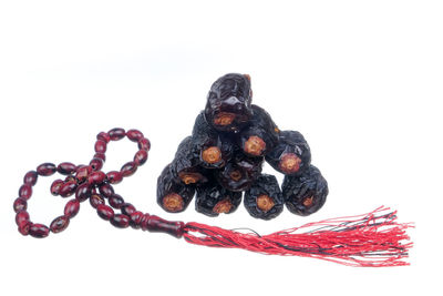 High angle view of berries on rope against white background
