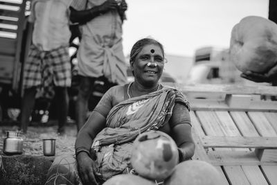 Portrait of smiling woman selling pumpkins at market