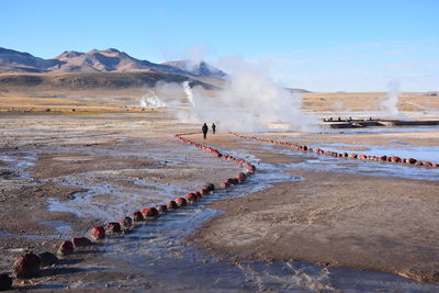 People at hot spring against mountain