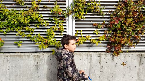 Full length of boy sitting against wall