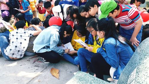 High angle view of people sitting on street