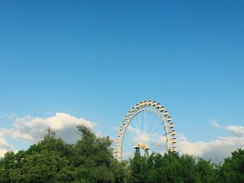 Low angle view of ferris wheel against blue sky