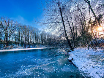 Scenic view of frozen river against sky during winter