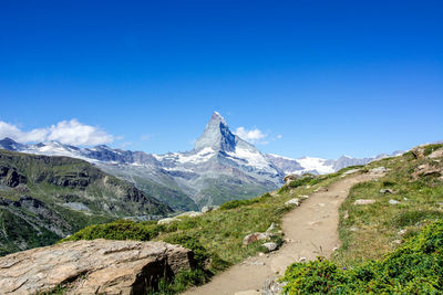 Scenic view of snowcapped mountains against clear blue sky