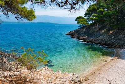Beautiful turquoise and blue water on empty beach in amazing cove in summer.