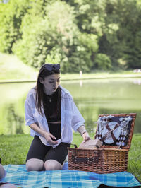 A young girl takes out dishes from a basket in the park.