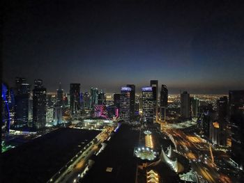 Illuminated buildings in city against sky at night