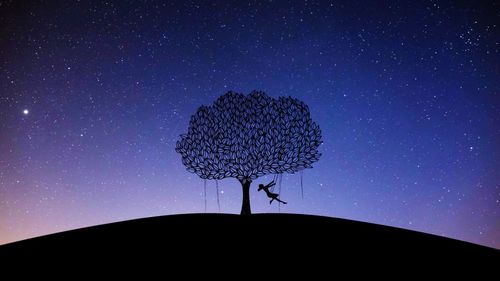 Low angle view of silhouette clock against sky at night