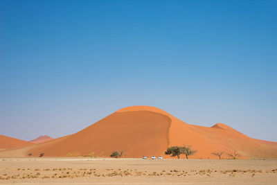 View of desert against clear blue sky