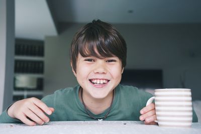 Close-up of cute boy eating food at home