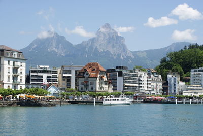 Buildings by sea against mountains