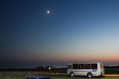 Cars on land against clear sky at night