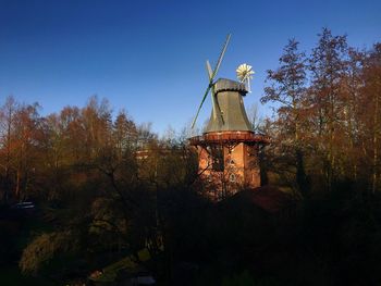 Low angle view of traditional windmill against clear sky