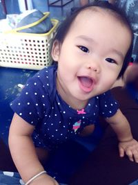 Portrait of cute baby girl sitting at home