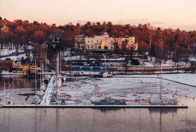 Boats moored at harbor against sky