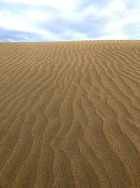 Sand dunes in desert against sky