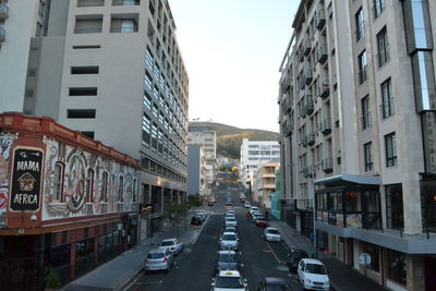 Traffic on road amidst buildings in city