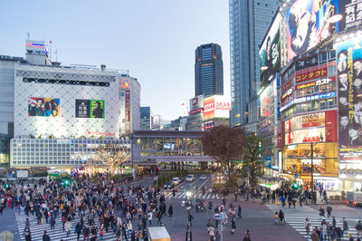 Crowd in city against clear sky
